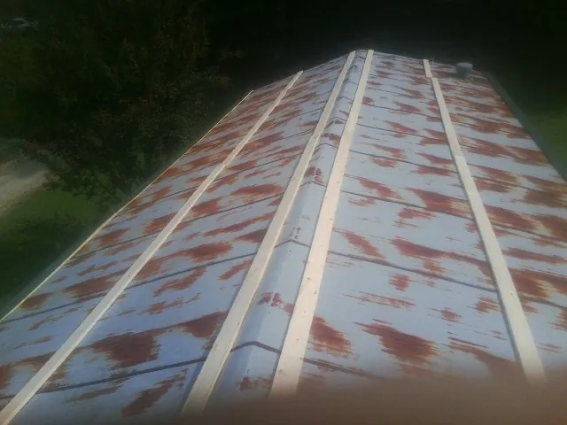 Rusted metal roof panels with new wood purlins before replacement — Storm Damage Roof Repair in Disputanta by Roofing Brothers