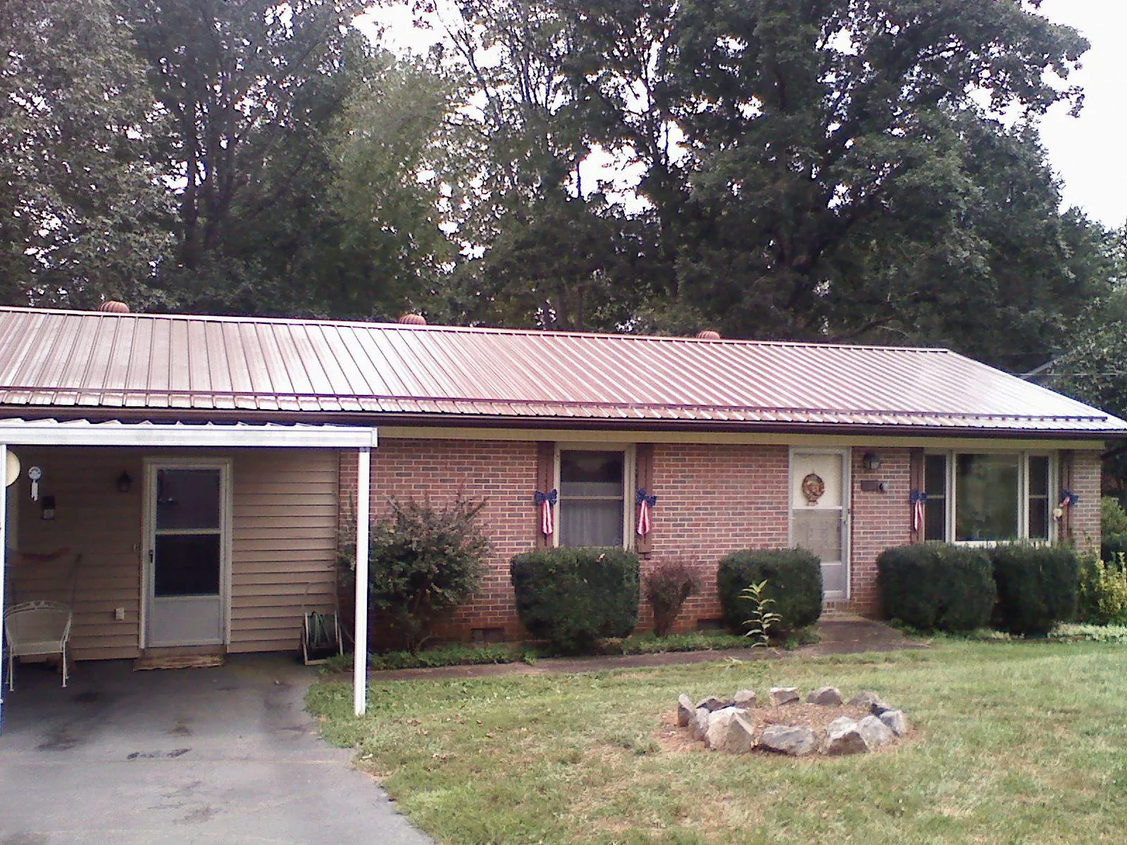 Bronze metal roof and carport on a brick ranch home — Roof Repair work by our crew in Disputanta